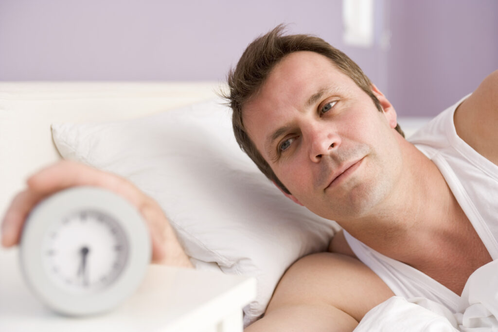 This image has an empty alt attribute; its file name is man-in-bed-reaching-for-clock-1817536-1024x683.jpg